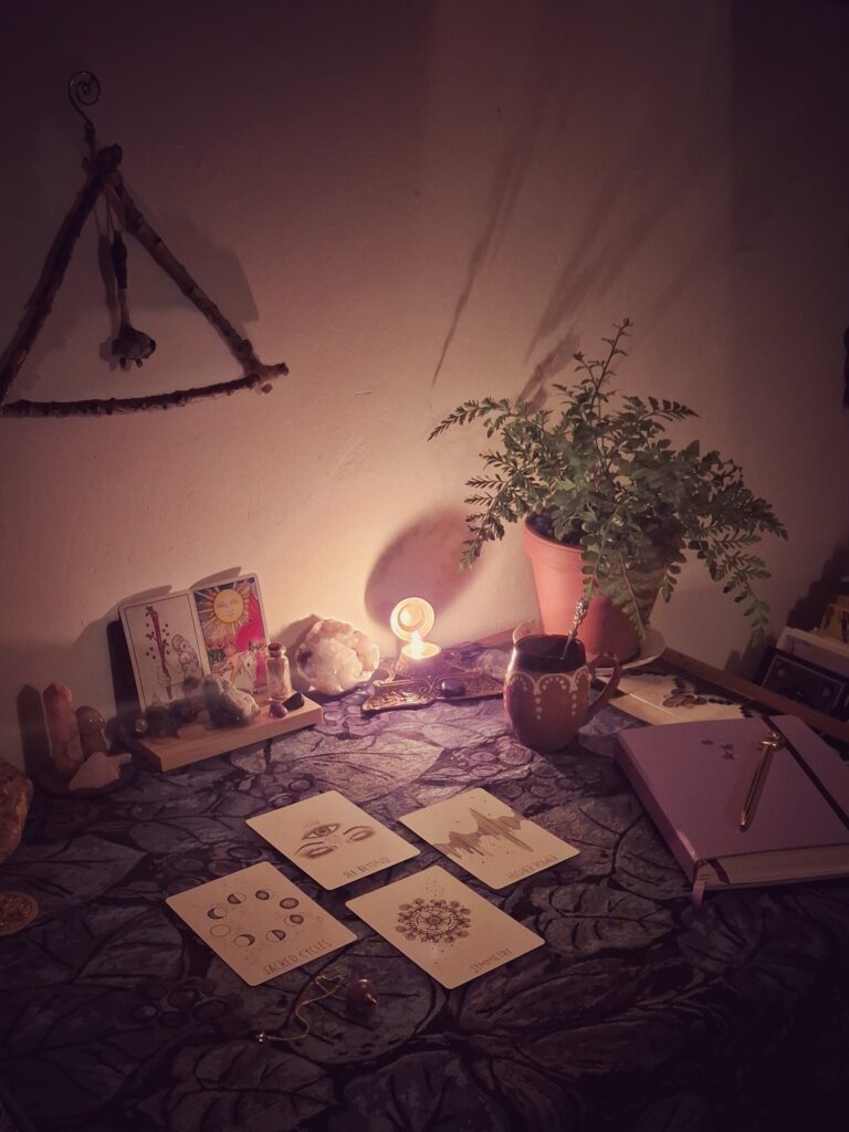 Sfeerbeeld van een rustig theeritueel met kruidenthee, tarotkaarten en kaarslicht.